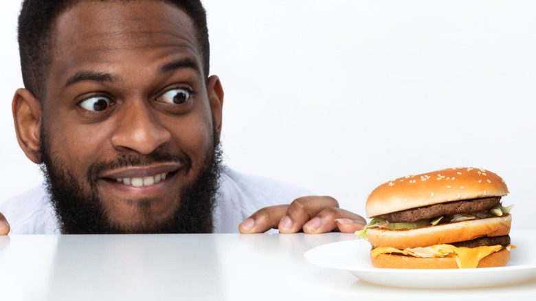 голодный мужчина смотрит на бургер