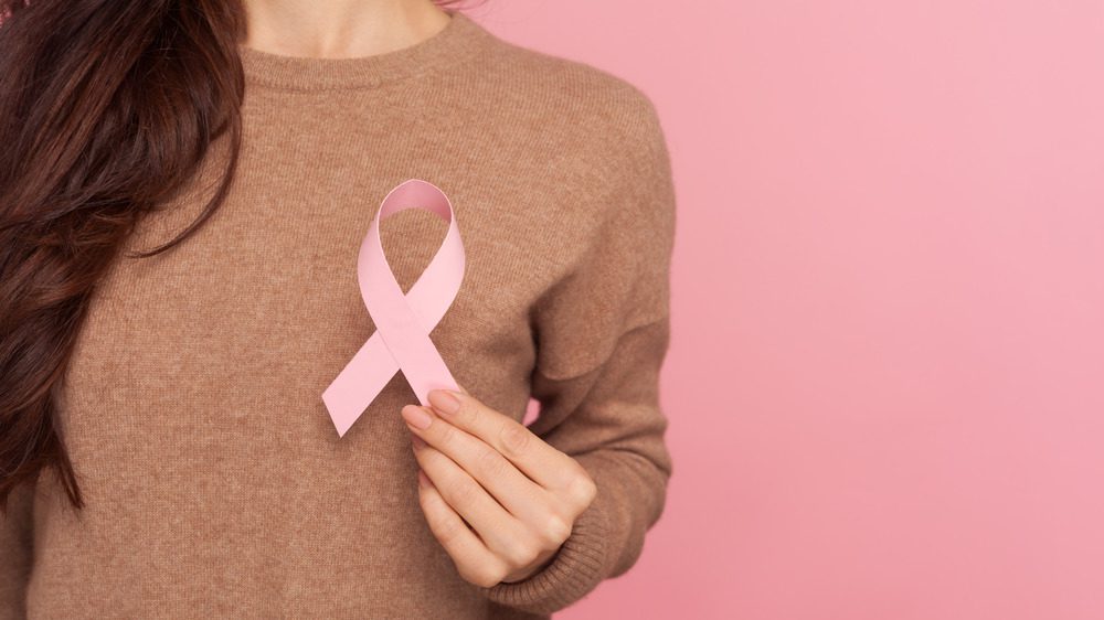 женщина носит ленту в поддержку рака груди