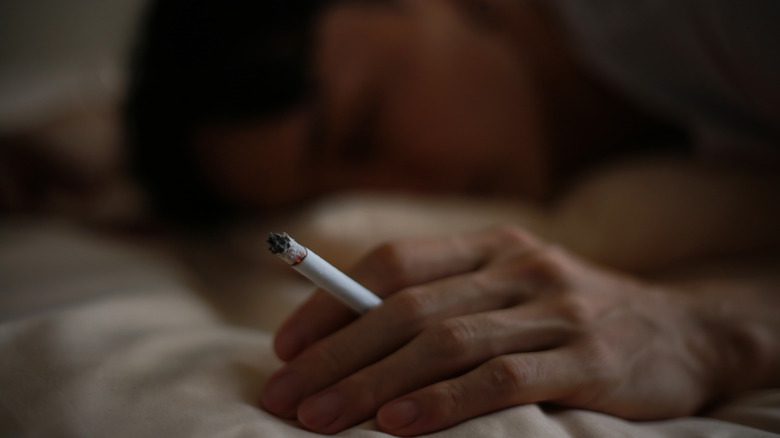 человек с сигаретой в постели