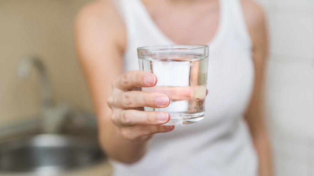 женщина держит стакан с водой