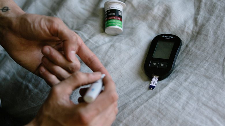 Женщина-диабетик проверяет уровень сахара в крови