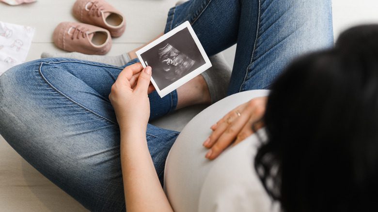 беременная женщина смотрит на ультразвуковую картинку