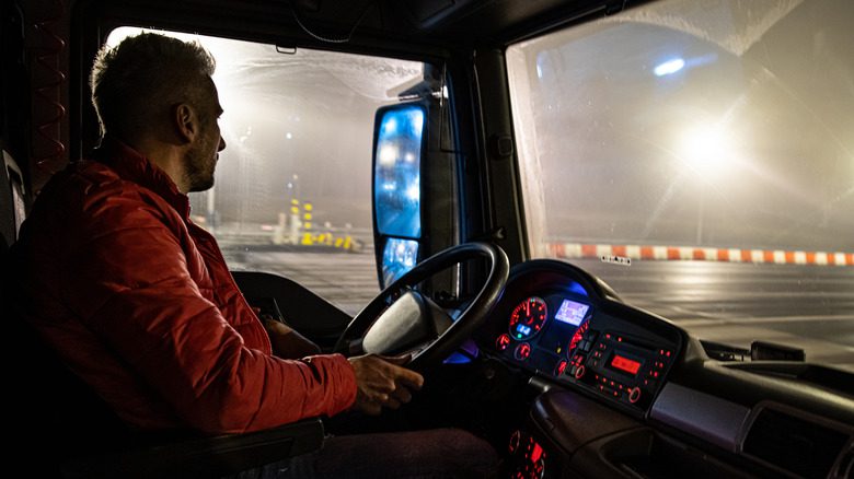 Водитель грузовика за рулем на шоссе ночью