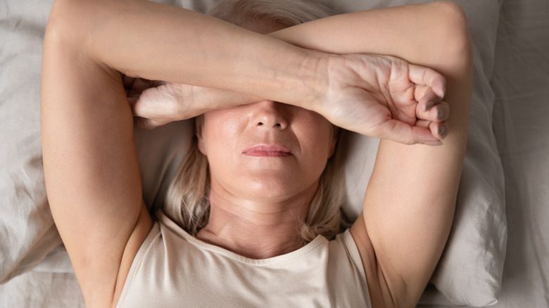 женщина с мигренью лежит в постели