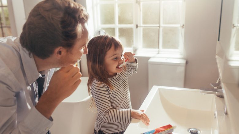 Отец и дочь чистят зубы