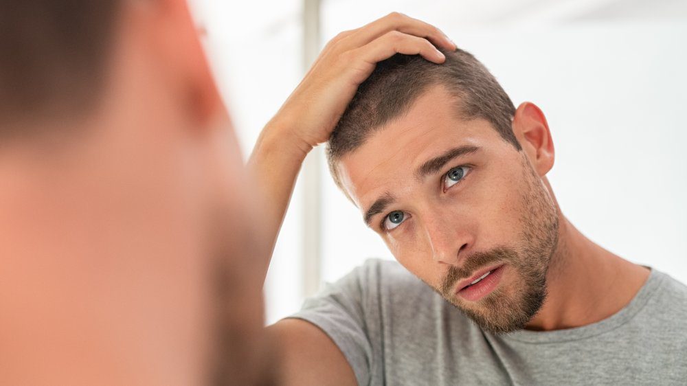 мужчина обеспокоен выпадением волос