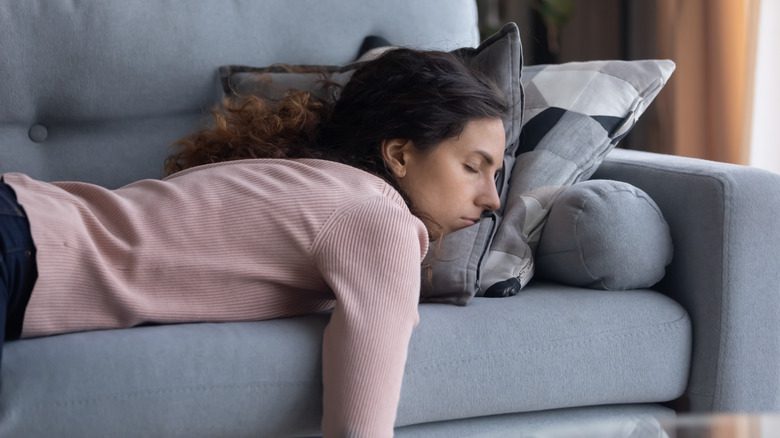 усталая женщина в менопаузе спит на диване