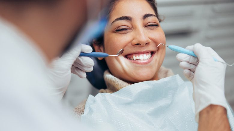 Женщина улыбается в кресле стоматолога
