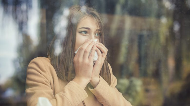 женщина с аллергией смотрит в окно