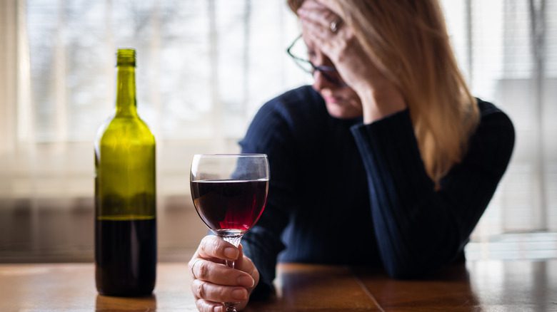 грустная женщина пьет вино