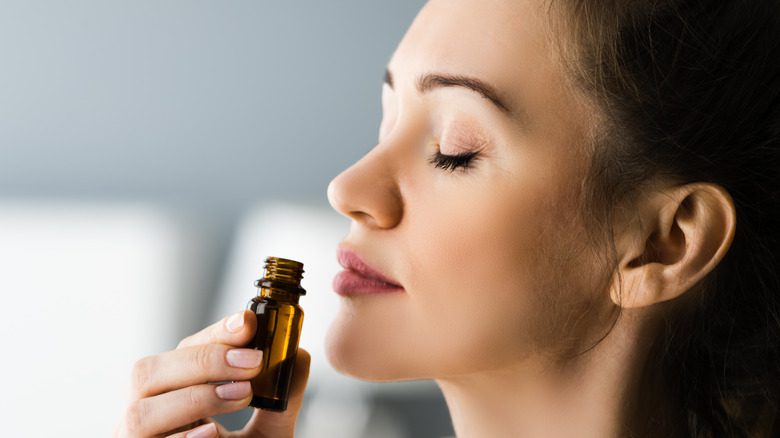 женщина набирает эфирное масло для ароматерапии