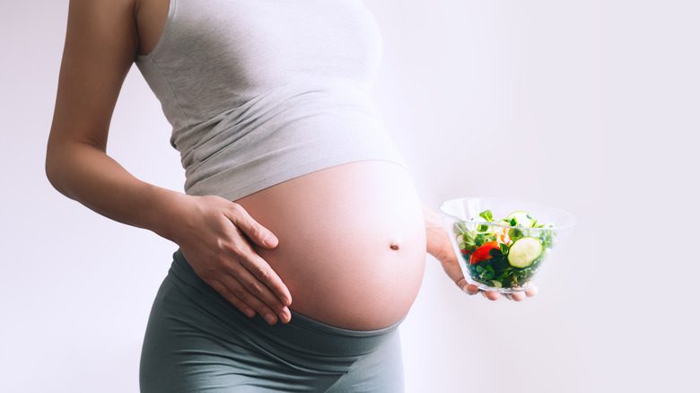 беременная женщина держит продукты, богатые фолатом