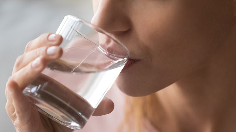 Женщина пьет стакан воды