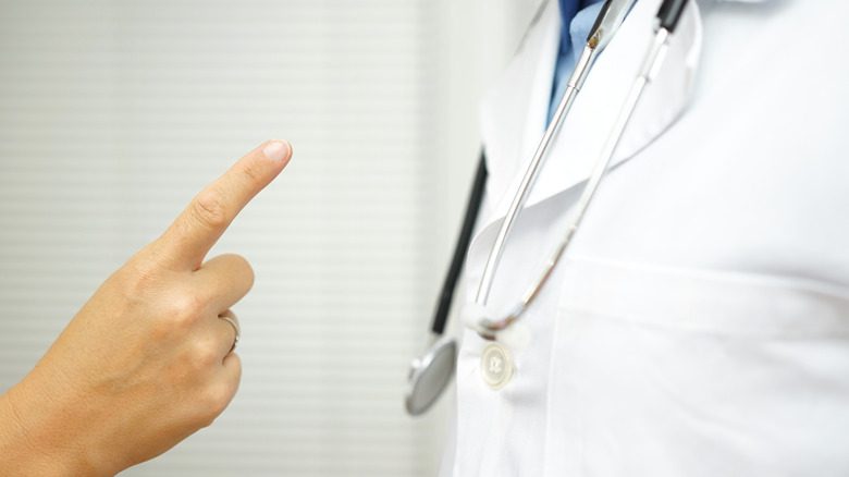 пациент показывает пальцем на врача
