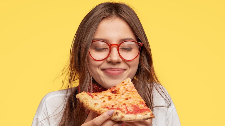 девочка-подросток ест кусок пиццы